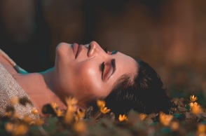 Ενα κορίτσι κάθεται στα χόρτα.