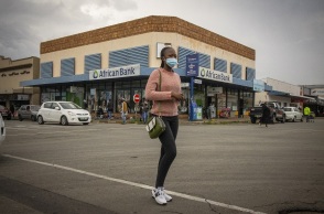 Γυναίκα με μάσκα περπατά σε δρόμο, στη Νότιο Αφρική