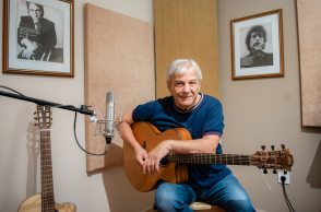 Ο Γιώργος Δημητριάδης κρατά ακουστική κιθάρα στο στούντιο