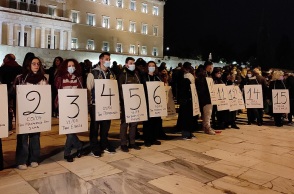 Συγκεντρωμένοι κρατούν πανό έξω από την Βουλή για τις γυναικοκτονίες 