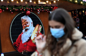 Κοπέλα με μάσκα για κορωνοϊό σε χριστουγεννιάτικη αγορά στο Λονδίνο