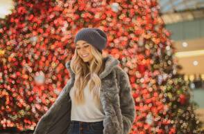 Ξανθιά κοπέλα μπροστά από το χριστουγεννιάτικο δέντρο