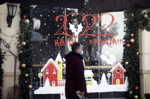 Άνδρας έξω από στολισμένη βιτρίνα μαγαζιού - Στιγμιότυπο από τη Θεσσαλονίκη την περίοδο των Χριστουγέννων 