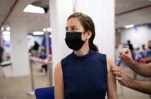Woman receiving Covid-19 vaccine at a vaccination center/Getty Images/Ideal Image