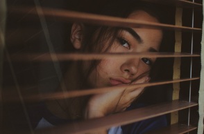 Ένα κορίτσι κοιτάζει έξω από το παράθυρο. 