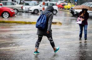 Άνθρωπος περπατά στη βροχή στο κέντρο της Αθήνας