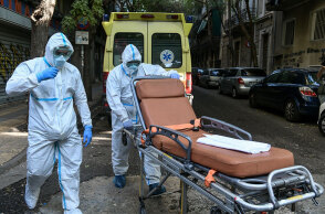 Υγειονομικοί του ΕΚΑΒ για τη μεταφορά ασθενών με κορωνοϊό σπρώχνουν φορείο