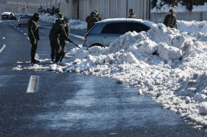 Στην Αττική Οδό στρατιώτες απομακρύνουν χιόνια από αυτοκίνητο