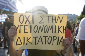 Γυναίκα που κρατά πλακάτ σε συγκέντρωση αντιεμβολιαστών