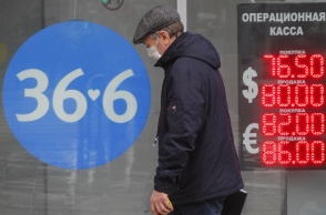Ρωσία: Άνδρας μπροστά από πίνακα ισοτιμίας για το ρούβλι με το ευρώ