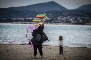 Μητέρα με το παιδί της πετούν χαρταετό στην παραλία της Λούτσας