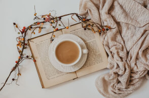 Ανοιχτό βιβλίο με φλιτζάνι καφέ ακουμπισμένο επάνω