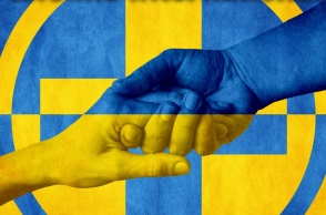 Εικόνα που δείχνει χειραψία με φόντο τη σημαία της ουκρανίας