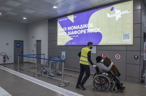 Υπάλληλος σε αεροδρόμιο βοηθά γυναίκα σε αμαξίδιο