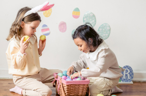 Δύο μικρά κορίτσια παίζουν με πασχαλινά αυγά