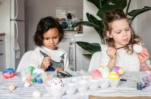 Δύο μικρά κοριτσάκια βάφουν πασχαλινά αυγά
