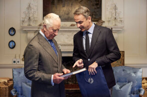 Ο Κυριάκος Μητσοτάκης χαρίζει στον πρίγκιπα Κάρολο έναν κατάλογο με τα εκθέματα από το νέο αρχαιολογικό μουσείο στα Χανιά