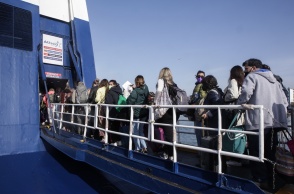 Πολίτες επιβιβάζονται σε πλοίο που αναχωρεί από το λιμάνι του Πειραιά