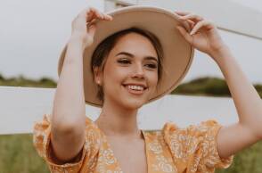 Νεαρή κοπέλα που φοράει καπέλο και χαμογελάει