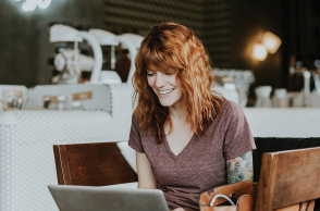 Γυναίκα που δουλεύει από το λάπτοπ της σε καφέ