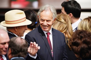 Ο Τόνι Μπλερ στο κέντρο της φωτογραφίας χαμογελά σε συνομιλητή του