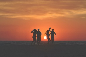 Τέσσερα άτομα χορεύουν στην παραλία. 