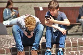 Δύο αγόρια που ασχολούνται με τα κινητά τους