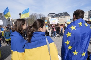 Δύο γυναίκες με τη σημαία της Ουκρανίας κι άντρας με τη σημαία της Ευρωπαϊκής Ένωσης σε πορεία