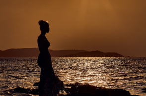 Ένα κορίτσι ποζάρει στο ηλιοβασίλεμα. 