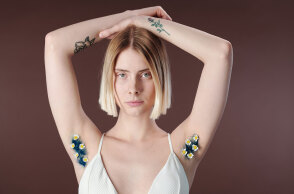 Γυναίκα με σηκωμένα χέρια και μπλε τρίχες στη μασχάλη με λουλουδάκια