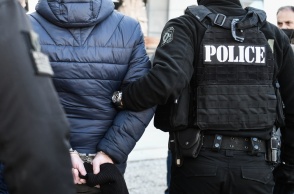 Άνδρας με χειροπέδες οδηγείται στο δικαστήριο συνοδευόμενος από αστυνομικούς