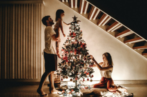 Τριμελής οικογένεια στολίζει το χριστουγεννιάτικο δέντρο 