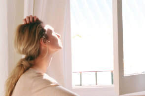 Μια κοπέλα κοιτάει έξω από το παράθυρο