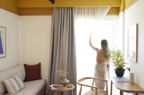 brown-beach-eretria-by-brown-hotels-guest-drawing-the-curtains-looking-at-the-view