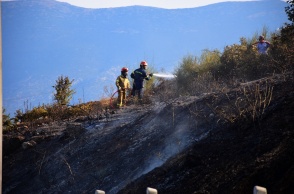 Πυροσβέστες με μάνικα επιχειρούν στην κατάσβεση πυρκαγιάς 