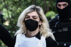 Η Ρούλα Πισπιρίγκου με μάσκα και αλεξίσφαιρο κατά τη μεταφορά της στον εισαγγελέα