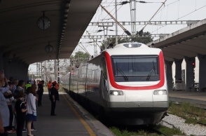 Συρμός της ΤΡΑΙΝΟΣΕ σε σταθμό και επιβάτες που αναμένουν για να επιβιβαστούν