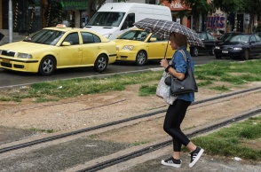 Γυναίκα με ομπρέλα περπατά σε δρόμο