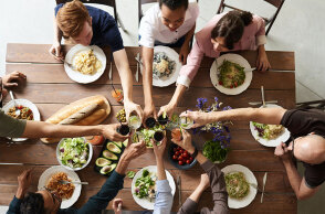 Παρέα τσουγκρίζει ποτήρια σε τραπέζι φαγητού