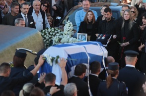 Το φέρετρο του Αλέξανδρου Νικολαΐδη σκεπασμένο με την ελληνική σημαία - Πίσω ο Μιχάλης Μουρούτσος κρατά τα μετάλλιά του