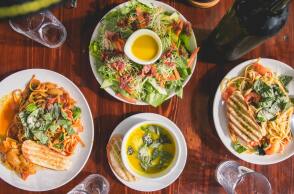 Γεύμα με σαλάτα, κρασί και δύο πιάτα στο τραπέζι