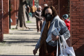 Ηλικιωμένη γυναίκα περπατά στον δρόμο κρατώντας περιοδικό