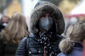 Γυναίκα με κουκούλα και κασκόλ προστατεύεται από το κρύο