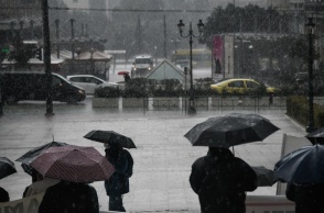 Πολίτες με ομπρέλες για την προστασία τους από την καταιγίδα στο κέντρο της Αθήνας
