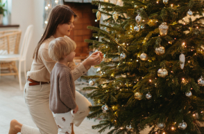 Μαμά και παιδί στολίζουν χριστουγεννιάτικο δέντρο
