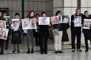 Συγγενείς θυμάτων της πύρινης τραγωδίας στο Μάτι κρατούν φωτογραφίες των νεκρών έξω από το δικαστήριο