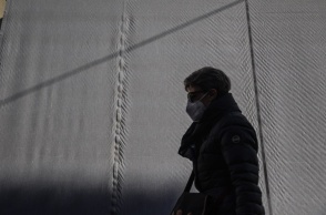 Γυναίκα περπατά φορώντας τη μάσκα προστασίας κατά του κορωνοϊού