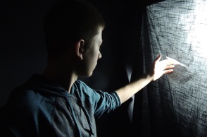 Αγόρι πίσω από κουρτίνα κοιτά μέσα από το κενό που υπάρχει