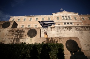 Άνδρας κυματίζει την ελληνική σημαία έξω από τη Βουλή των Ελλήνων