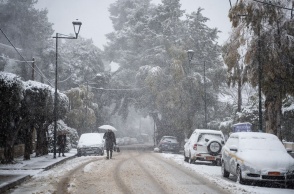 Γυναίκα με ομπρέλα στα χιόνια της Αττικής